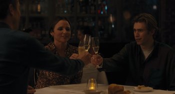 Movie still from “You Hurt My Feelings” (2023), directed by Nicole Holofcener – A group of people sitting at a table holding wine glasses; Medium shot, Over the shoulder angle