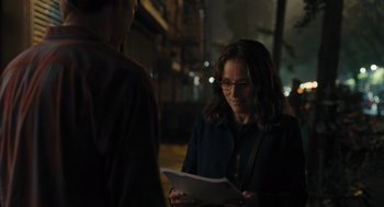 Movie still from “You Hurt My Feelings” (2023), directed by Nicole Holofcener – A woman in glasses is reading a paper; Medium shot, Over the shoulder angle