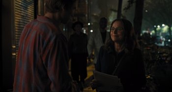 Movie still from “You Hurt My Feelings” (2023), directed by Nicole Holofcener – A woman is talking to a man in a crowd of onlookers; Medium shot, Over the shoulder angle