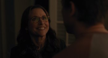 Movie still from “You Hurt My Feelings” (2023), directed by Nicole Holofcener – A woman wearing glasses is smiling at a man; Close Up shot, Over the shoulder angle
