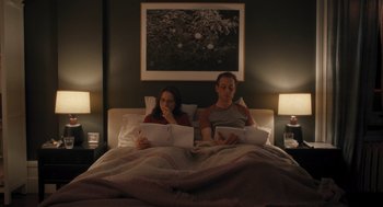 Movie still from “You Hurt My Feelings” (2023), directed by Nicole Holofcener – Two people sitting in a bed with papers in their hands; Medium shot, High angle