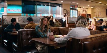 Movie still from “You People” (2023), directed by Kenya Barris – A woman sitting at a table with a plate of food in front of a man; Medium shot, Over the shoulder angle