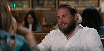 Movie still from “You People” (2023), directed by Kenya Barris – A man sitting at a table in front of a glass of water; Close Up shot, Over the shoulder angle