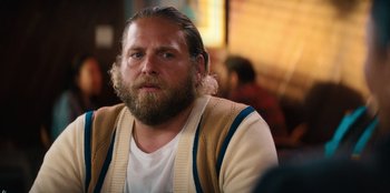 Movie still from “You People” (2023), directed by Kenya Barris – A man with long hair and a beard is sitting in front of some people; Close Up shot, Over the shoulder angle