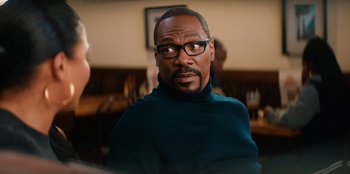 Movie still from “You People” (2023), directed by Kenya Barris – A person wearing glasses and a sweater; Close Up shot, Over the shoulder angle