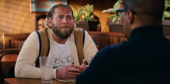 Movie still from “You People” (2023), directed by Kenya Barris – A man sitting at a table talking to another man; Close Up shot, Over the shoulder angle