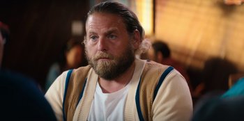 Movie still from “You People” (2023), directed by Kenya Barris – A man with long hair and a beard is sitting in front of a group of people; Close Up shot, Over the shoulder angle