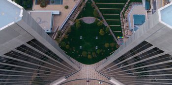 Movie still from “You People” (2023), directed by Kenya Barris – An aerial view looking down at a park in the middle of a building; Extreme Wide shot, Overhead angle