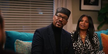 Movie still from “You People” (2023), directed by Kenya Barris – A man wearing a hat and a jacket; Medium shot, Over the shoulder angle