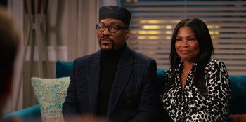 Movie still from “You People” (2023), directed by Kenya Barris – A man and a woman sitting next to each other on a couch; Medium shot, Over the shoulder angle