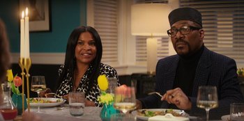 Movie still from “You People” (2023), directed by Kenya Barris – A man and a woman sitting at a dinner table; Medium shot, Over the shoulder angle