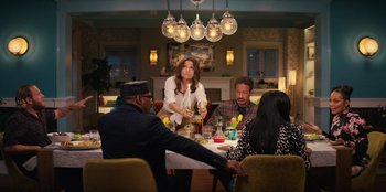 Movie still from “You People” (2023), directed by Kenya Barris – A group of people sitting at a table with food; Medium shot, Over the shoulder angle