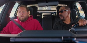 Movie still from “You People” (2023), directed by Kenya Barris – Two men sitting in the back seat of a car; Medium shot, Over the shoulder angle