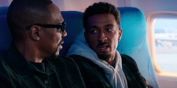 Movie still from “You People” (2023), directed by Kenya Barris – Two men sitting next to each other on a plane; Close Up shot, Over the shoulder angle