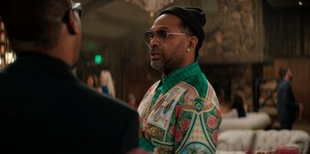 Movie still from “You People” (2023), directed by Kenya Barris – A person wearing sunglasses and a hat; Medium shot, Over the shoulder angle