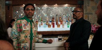 Movie still from “You People” (2023), directed by Kenya Barris – A couple of men standing next to each other at a bar; Medium shot, Low angle