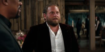 Movie still from “You People” (2023), directed by Kenya Barris – A man with long hair and a beard wearing a white shirt; Close Up shot, Over the shoulder angle