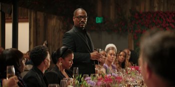 Movie still from “You People” (2023), directed by Kenya Barris – A group of people sitting around a table with wine glasses; Medium shot, Over the shoulder angle