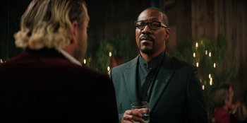 Movie still from “You People” (2023), directed by Kenya Barris – A man in a suit and tie talking to another man in a suit and tie; Close Up shot, Over the shoulder angle