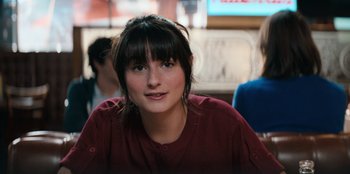 Movie still from “You People” (2023), directed by Kenya Barris – A woman with bangs sitting at a table; Close Up shot, Over the shoulder angle
