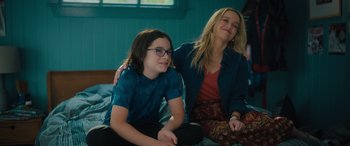 Movie still from “Your Place or Mine” (2023), directed by Aline Brosh McKenna – A woman sitting next to a young boy on a bed; Medium shot, Over the shoulder angle