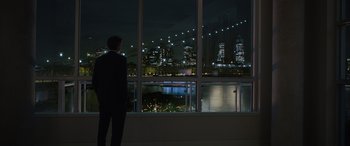Movie still from “Your Place or Mine” (2023), directed by Aline Brosh McKenna – A man standing in front of a large window at night; Wide shot, Over the shoulder angle
