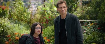 Movie still from “Your Place or Mine” (2023), directed by Aline Brosh McKenna – A man standing next to a young girl in front of a garden; Medium shot, Over the shoulder angle