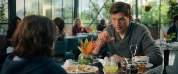 Movie still from “Your Place or Mine” (2023), directed by Aline Brosh McKenna – A man sitting at a table in front of a plate of food; Medium shot, Over the shoulder angle