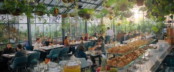 Movie still from “Your Place or Mine” (2023), directed by Aline Brosh McKenna – A group of people sitting at a table in a restaurant; Wide shot, Over the shoulder angle
