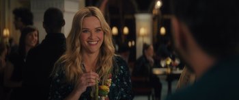 Movie still from “Your Place or Mine” (2023), directed by Aline Brosh McKenna – A woman smiles while holding a bunch of fruit; Close Up shot, Over the shoulder angle