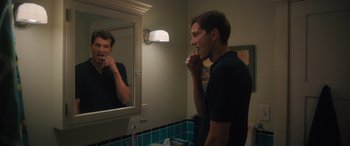 Movie still from “Your Place or Mine” (2023), directed by Aline Brosh McKenna – A man brushing his teeth in front of a mirror; Medium shot, Over the shoulder angle