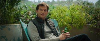 Movie still from “Your Place or Mine” (2023), directed by Aline Brosh McKenna – A man sitting on top of a chair holding a bottle of beer; Close Up shot, Over the shoulder angle