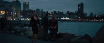 Movie still from “Your Place or Mine” (2023), directed by Aline Brosh McKenna – Three women are walking along the shore of a body of water at night; Wide shot, Over the shoulder angle