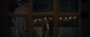 Movie still from “Your Place or Mine” (2023), directed by Aline Brosh McKenna – A man sitting on a couch holding a coffee cup; Medium shot, Over the shoulder angle