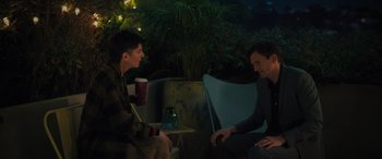 Movie still from “Your Place or Mine” (2023), directed by Aline Brosh McKenna – Two men are sitting on a chair and one of them is holding a drink; Medium shot, Over the shoulder angle
