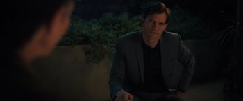 Movie still from “Your Place or Mine” (2023), directed by Aline Brosh McKenna – A man in a suit sitting on a bench; Medium shot, Over the shoulder angle