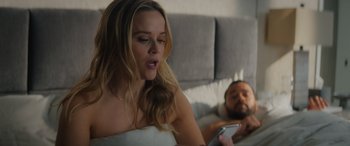 Movie still from “Your Place or Mine” (2023), directed by Aline Brosh McKenna – A beautiful woman sitting in a bed next to a bearded man; Medium shot, Over the shoulder angle