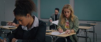 Movie still from “Your Place or Mine” (2023), directed by Aline Brosh McKenna – A woman sitting at a table writing on a piece of paper; Medium shot, Over the shoulder angle