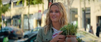 Movie still from “Your Place or Mine” (2023), directed by Aline Brosh McKenna – A beautiful young lady holding a plant in her hand; Close Up shot, Low angle