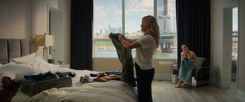 Movie still from “Your Place or Mine” (2023), directed by Aline Brosh McKenna – A woman is holding a blanket on a hotel bed; Wide shot, Over the shoulder angle