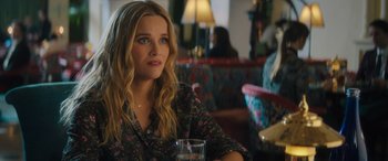 Movie still from “Your Place or Mine” (2023), directed by Aline Brosh McKenna – A person sitting at a table with a drink; Close Up shot, Over the shoulder angle