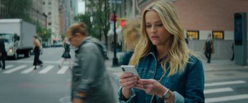 Movie still from “Your Place or Mine” (2023), directed by Aline Brosh McKenna – A woman is looking at her cell phone on the sidewalk; Close Up shot, High angle