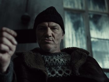 Movie still from “Zack Snyder's Justice League” (2021), directed by Zack Snyder – An older man wearing a sweater and a hat taking a selfie; Close Up shot, Low angle