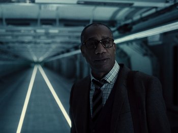 Movie still from “Zack Snyder's Justice League” (2021), directed by Zack Snyder – A man in a suit and tie standing in a tunnel; Close Up shot, Low angle