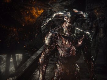 Movie still from “Zack Snyder's Justice League” (2021), directed by Zack Snyder – An evil looking creature is standing next to a fire pit; Wide shot, High angle