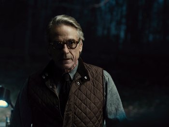 Movie still from “Zack Snyder's Justice League” (2021), directed by Zack Snyder – An older man wearing a brown vest and glasses; Close Up shot, Low angle