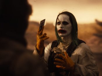 Movie still from “Zack Snyder's Justice League” (2021), directed by Zack Snyder – A person with a joker makeup holding a cell phone; Close Up shot, Over the shoulder angle