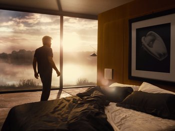Movie still from “Zack Snyder's Justice League” (2021), directed by Zack Snyder – A man standing in front of a window in a bedroom; Wide shot, Low angle