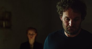 Movie still from “Zero Dark Thirty” (2012), directed by Kathryn Bigelow – A man and a woman standing next to each other in a room; Close Up shot, Low angle