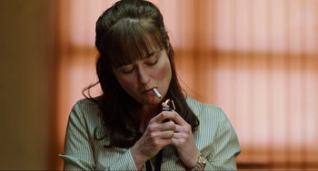 Movie still from “Zero Dark Thirty” (2012), directed by Kathryn Bigelow – A woman smoking a cigarette while holding a cell phone; Close Up shot, High angle